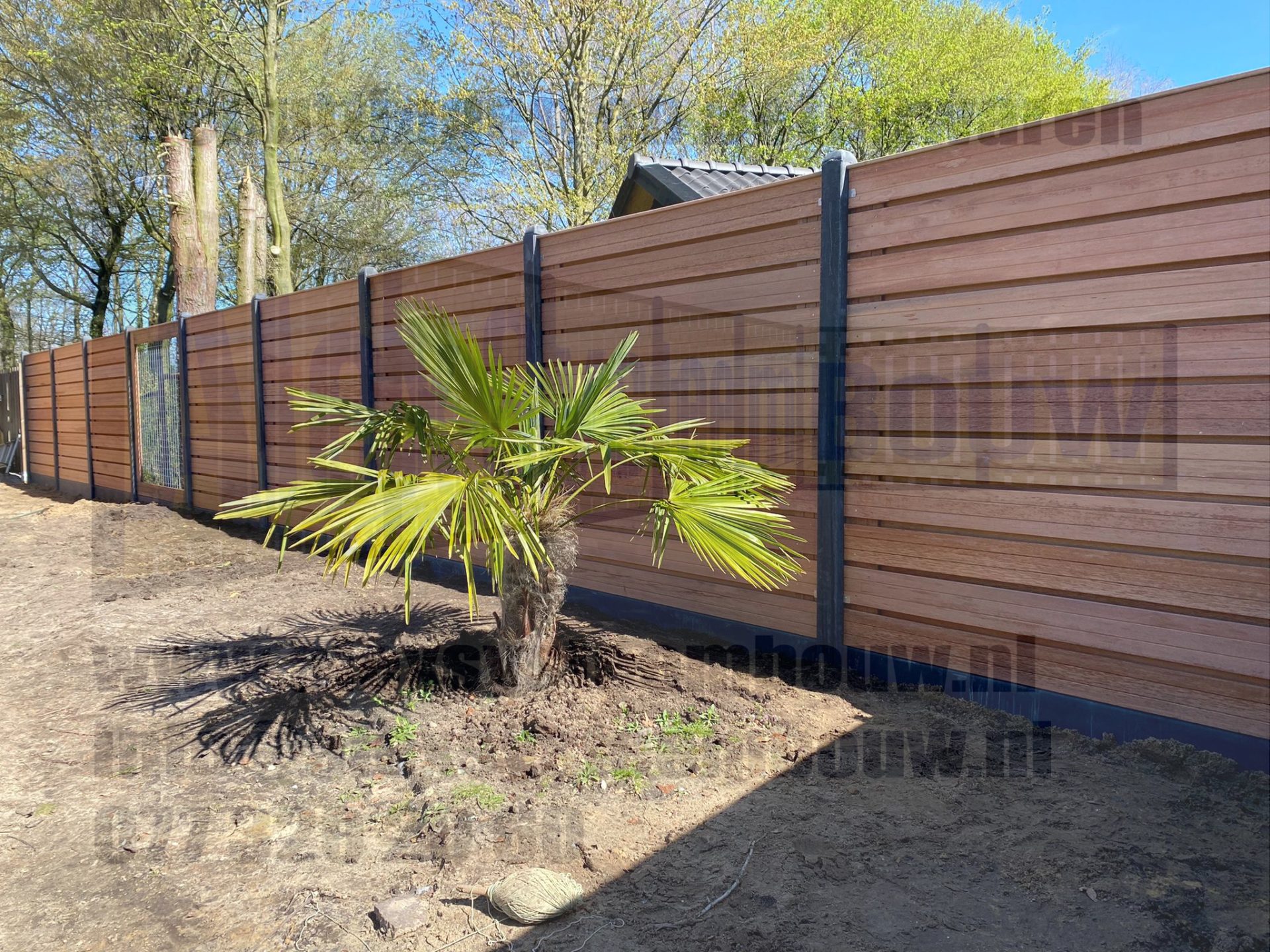Hardhout: 23 planks horizontale tuinschermen in combinatie met antracieten betonpalen voorzien van kegelkop