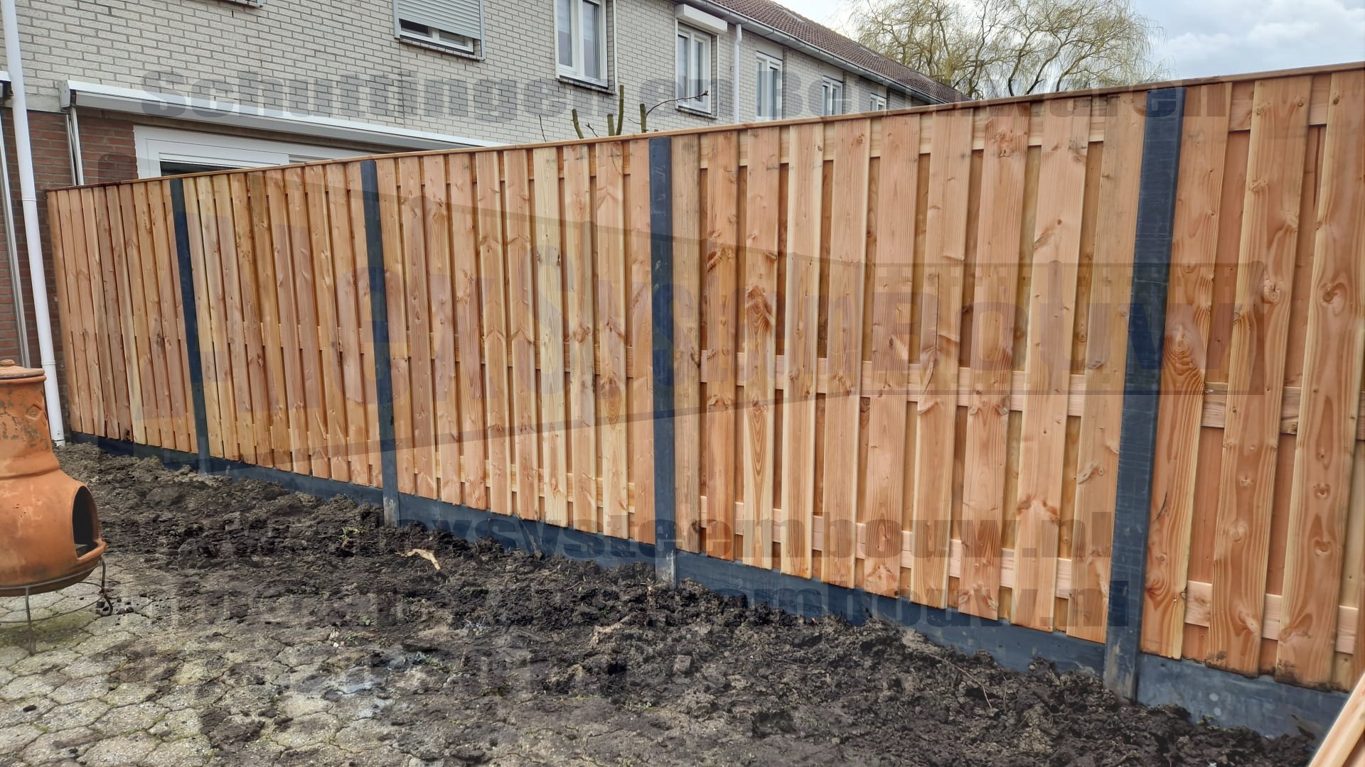 Deze hout beton schutting hebben wij voorzien van 21 planks lariks/douglas houten tuinschermen en zijn voorzien van één extra middenplank.